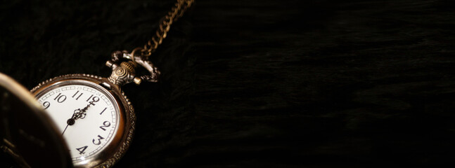 A classic old and retro watch with the twelve o'clock hour marked, set against a clean black background. This image is perfect for a New Year banner or countdown, with ample copy space