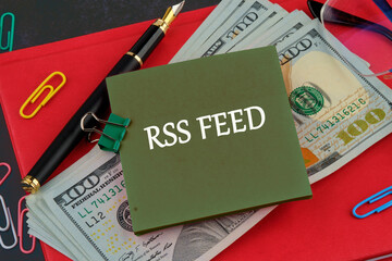 Focus on RSS Feed Documentation With Money and Office Supplies on a Workspace Table During a Typical Business Day