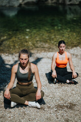 Two women practice meditation and mindfulness near a serene riverbank, promoting tranquility and...