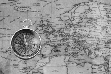 Classic round compass on background of old vintage map of world