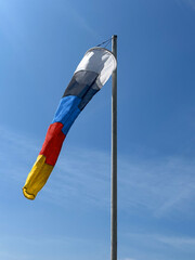 Four colored windsock with light wind on clear sky background