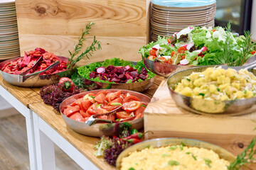 A Colorful Assortment of Fresh Salads and Vegetables Arranged on a Wooden Table, Showcasing a Variety of Healthy Ingredients for a Delightful Meal Spread