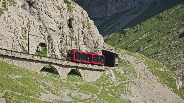 Red Cogwheel Train Entering Tunnel on Mount Pilatus Railway, Switzerland