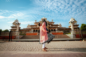 Romantic Indian couple in traditional attire posing in front of the iconic Albert Hall Museum in...