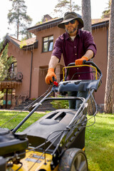 Man mowing lawn with a yellow lawnmower in a backyard