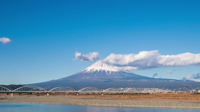 Timelapse clouds rolling over Mount Fuji and the Fujikawa bridge, Shizuoka, Japan 
