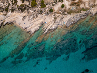 Aerial view of rocky coastline with turquoise water and pine forest in Greece. Stunning seascape...