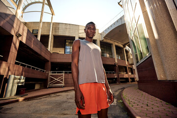 Athletic man posing in urban background under bright sunlight