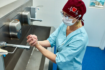 Medical professional washing hands in a sterile hospital environment