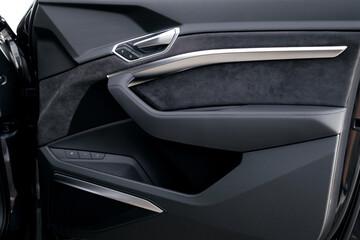 Interior of a premium electric SUV, black leather, aluminum, decorative elements.