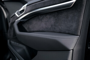 Interior of a premium electric SUV, black leather, aluminum, decorative elements.