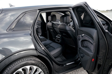 Interior of a premium electric SUV, black leather, aluminum, decorative elements.