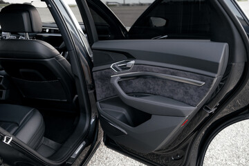 Interior of a premium electric SUV, black leather, aluminum, decorative elements.