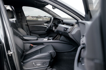 Interior of a premium electric SUV, black leather, aluminum, decorative elements.