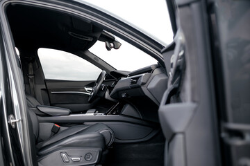 Interior of a premium electric SUV, black leather, aluminum, decorative elements.
