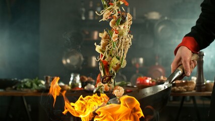 flying fresh ingredients in wok pan with whipping flames