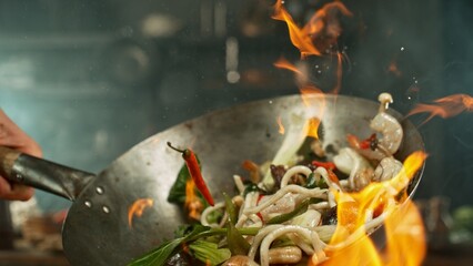 flying fresh ingredients in wok pan with whipping flames