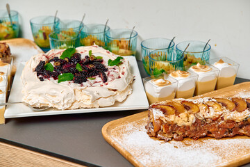 Delicious Dessert Display Featuring Pavlova, Fruit Cups, and Nut Bar, Perfect for Any Celebration...