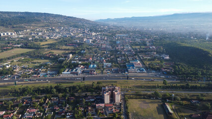 Aerial View of Urban Landscape with Hills and Modern Buildings, Intersected by a Highway