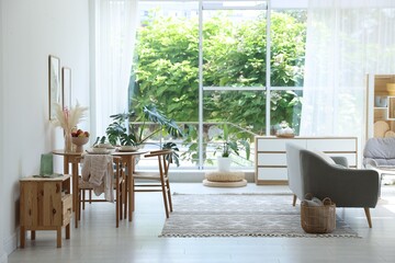Stylish table setting, chairs, sofa and decor in dining room. Interior design