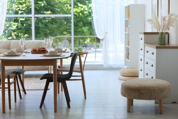 Beautiful table setting, chairs and decor in dining room. Interior design