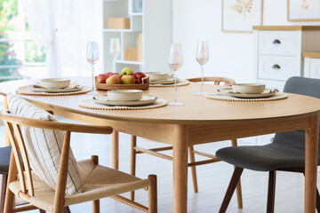 Beautiful table setting, chairs and decor in dining room. Interior design