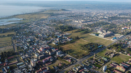 Aerial view showcasing Nakuru, Kenya, a city with diverse architecture and surrounding landscape on a clear day.
