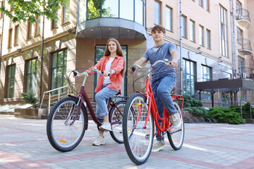 Obraz premium Teenage girl and boy riding bicycles on city street
