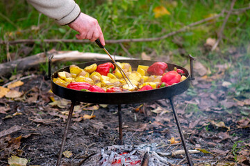 Cooking vegetables on the fire in the forest in autumn. Selective focus