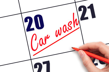 20th day of the month.  Hand writing Car wash reminder and drawing a line on calendar with red pen...