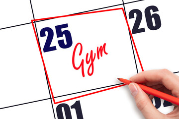 25th day of the month. Hand writing Gym reminder and drawing red frame on calendar with red pen on...