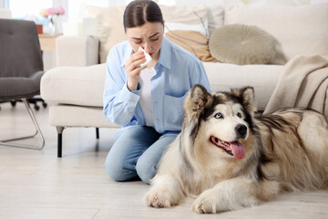 Woman suffering from allergy with her dog at home