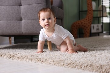 Cute little baby crawling on carpet at home
