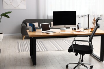 Stylish workplace with modern computer, other devices and stationery on wooden desk indoors