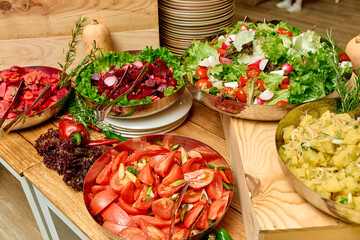 A Vibrant Display of Fresh Salads Featuring a Variety of Colorful Vegetables, Including Romaine Lettuce, Tomatoes, Beets, and Fresh Herbs on a Wooden Table
