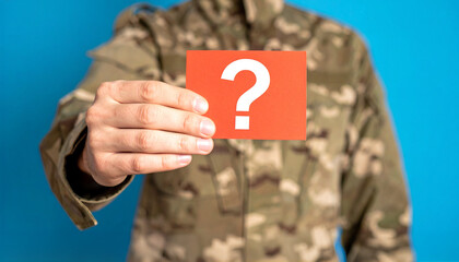 A person in military uniform holding a card with a question mark on it, seeking answers or questioning something. The image sparks curiosity and hints at unanswered questions.