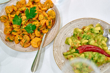 A Colorful Display of Deliciously Prepared Plant-Based Dishes Featuring Spiced Carrots and Avocado Salad Garnished with Fresh Herbs and Chili Peppers