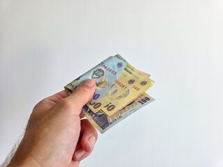 Romanian lei bank notes held in hand against a white background