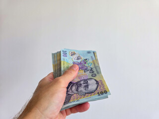Romanian lei bank notes held in hand against a white background