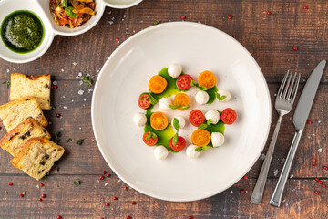 Colorful Caprese salad with cherry tomatoes, mozzarella and fresh basil