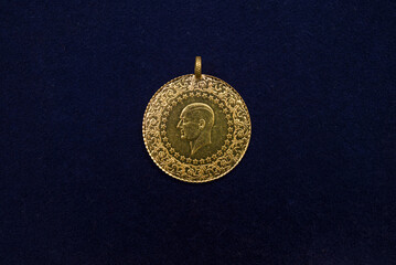 Close-up of traditional Turkish gold coin on dark blue background