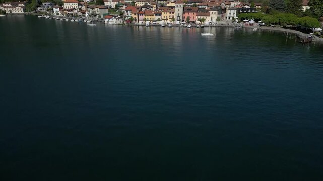 Close-Up Aerial Tilt-Up from Lake Orta to Pella Waterfront, Italy &ndash; Colorful Village Facades and Boats

