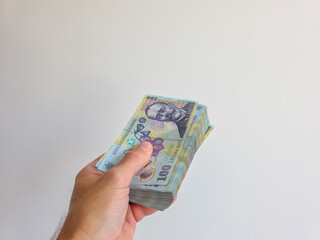 Romanian lei bank notes held in hand against a white background