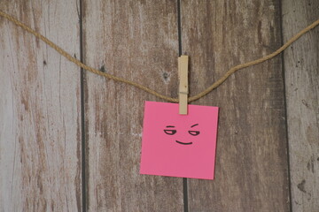 post it color rosa carita sonriente fondo madera vieja