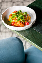 Plakat Top view of a bowl with noodles, cherry tomatoes, and cilantro on a rustic green table, capturing a vibrant and appetizing vegetarian meal.