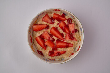 Delicious Bowl of Oatmeal Topped with Fresh Strawberries and a Drizzle of Syrup for a Nutritious...
