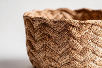 Photorealistic close-up of a woven jute basket with intricate chevron patterns