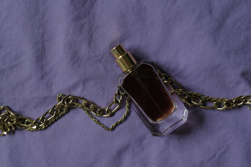 perfume bottle with brown liquid on a purple background