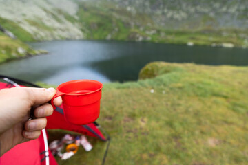 Obraz premium red camping coffee cup by lake