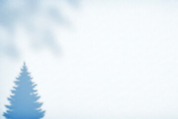 minimalist winter background featuring the ethereal blue shadow of a Christmas tree cast on a blank white surface, creating an abstract holiday design with ample copy space